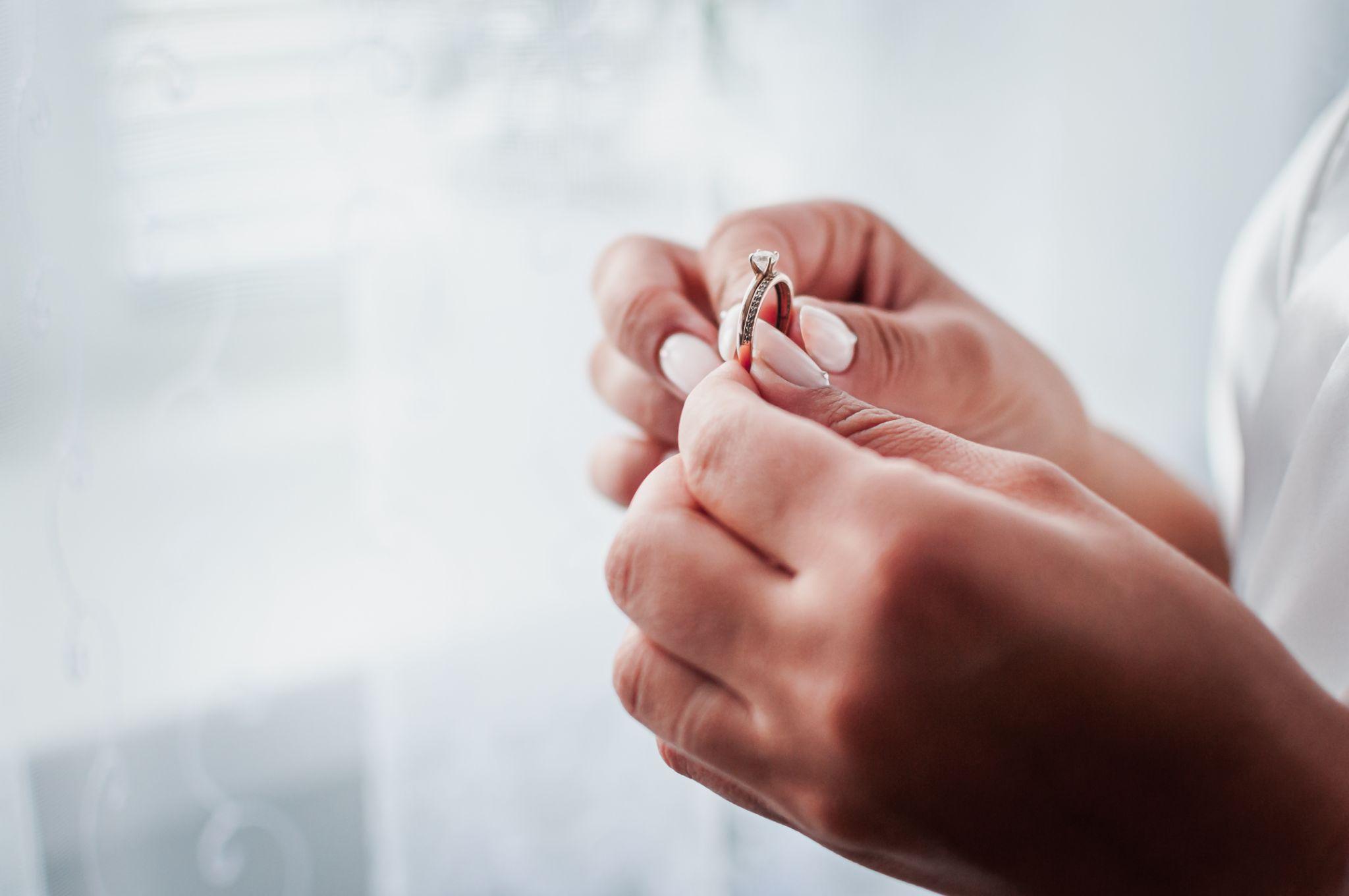 Bride hold gold diamond wedding ring in the hand