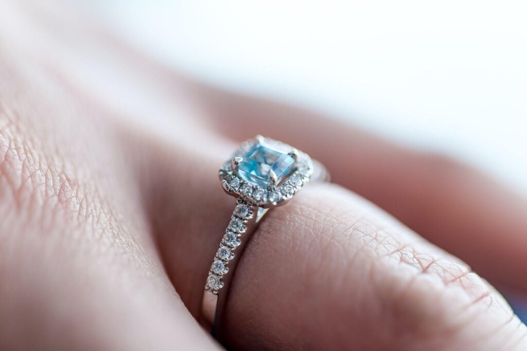 Diamond engagement ring on finger.